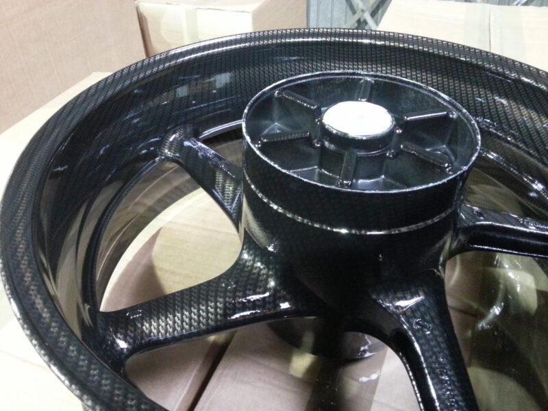 Motorbike alloy wheels coated in carbon fibre painted black