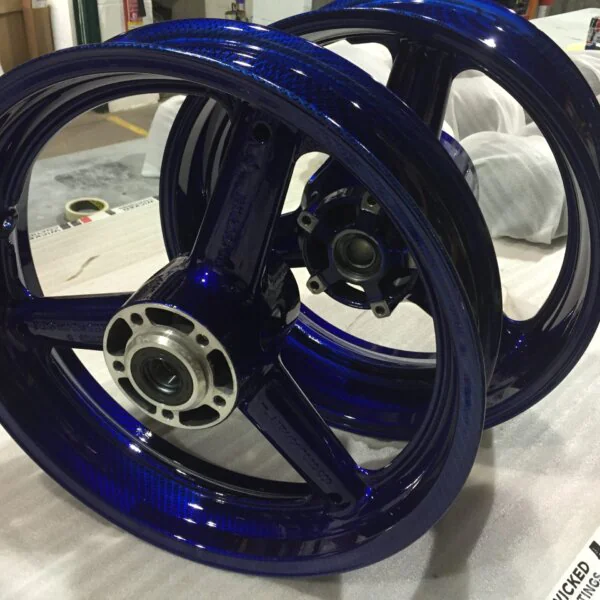 Motorbike wheels coated in carbon fibre painted dark blue