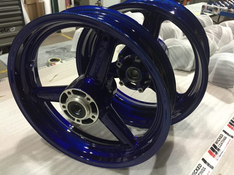 Motorbike wheels coated in carbon fibre painted dark blue