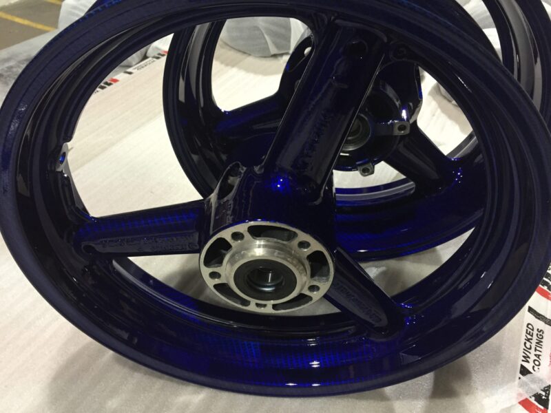 Motorbike wheels coated in carbon fibre painted dark blue