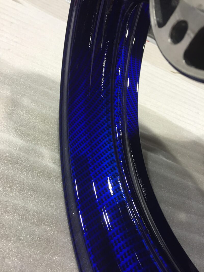 Motorbike wheels coated in carbon fibre painted dark blue