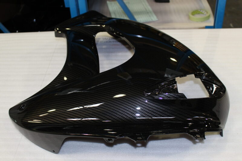 Various motorbike parts coated in carbon fibre