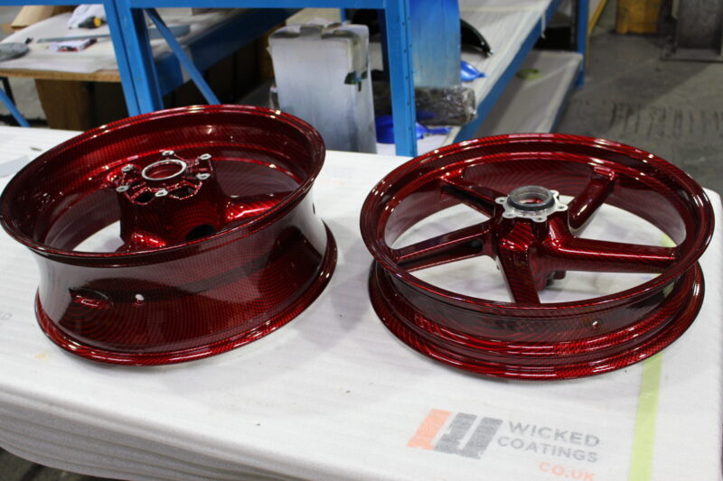 Motorbike alloy wheels coated in carbon fibre painted dark red
