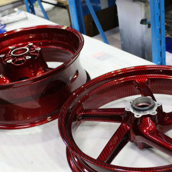 Motorbike alloy wheels coated in carbon fibre painted dark red