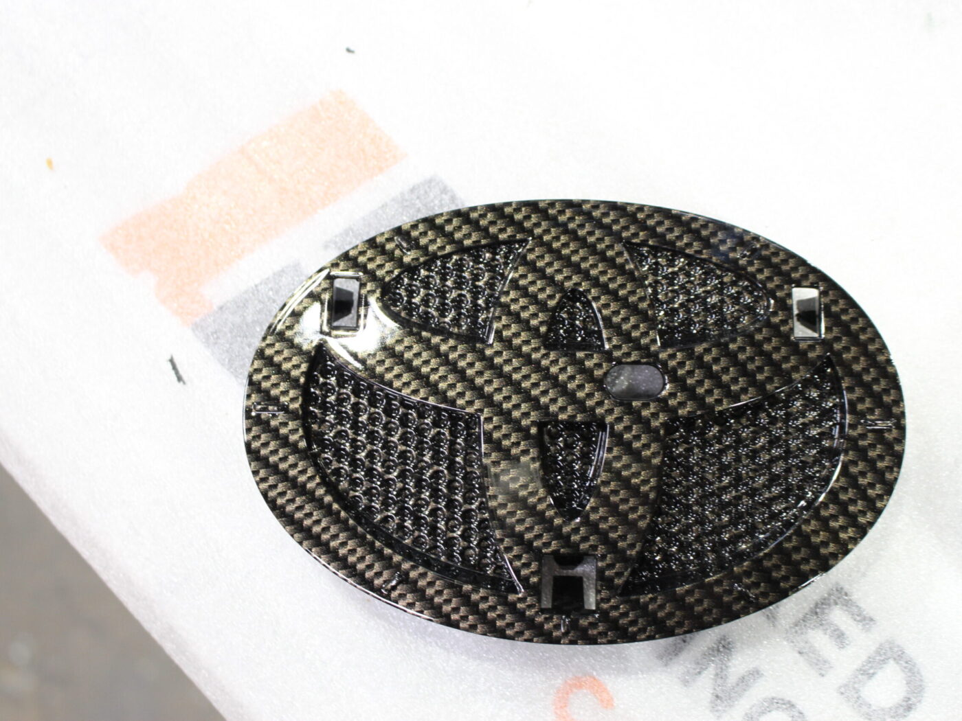 Radiator cover coated in carbon fibre