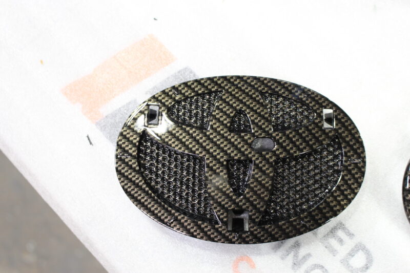 Radiator cover coated in carbon fibre