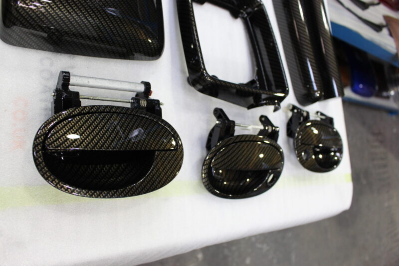Various car interior parts coated in carbon fibre