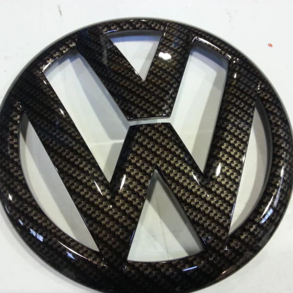 VW car badge coated in carbon fibre hydrographic film painted black