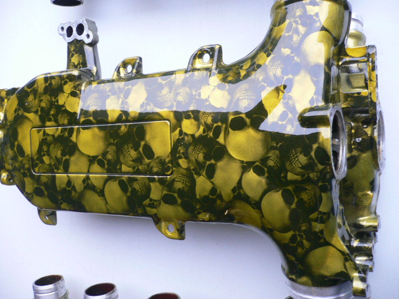 Car engine part coated in skull and carbon fibre painted yellow