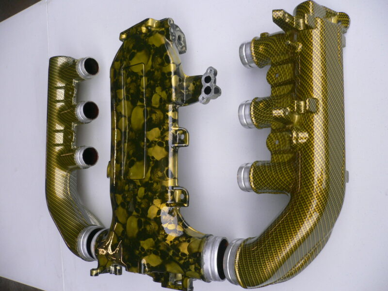 Car engine part coated in skull and carbon fibre painted yellow