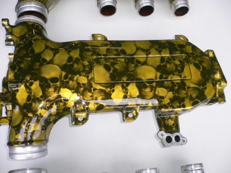 Car engine part coated in skull and carbon fibre painted yellow