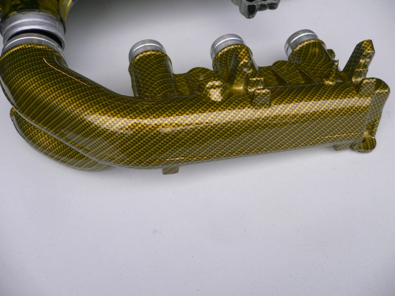 Car engine part coated in skull and carbon fibre painted yellow