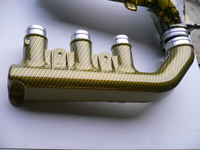 Car engine part coated in skull and carbon fibre painted yellow
