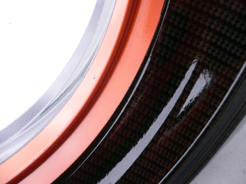 Motorbike alloy wheels coated in carbon fibre painted black and orange