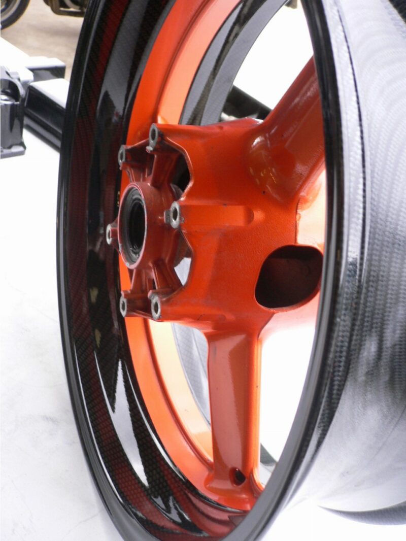Motorbike alloy wheels coated in carbon fibre painted black and orange