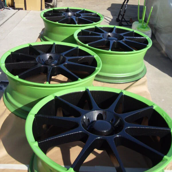 Car alloy wheels coated in carbon fibre painted black and green