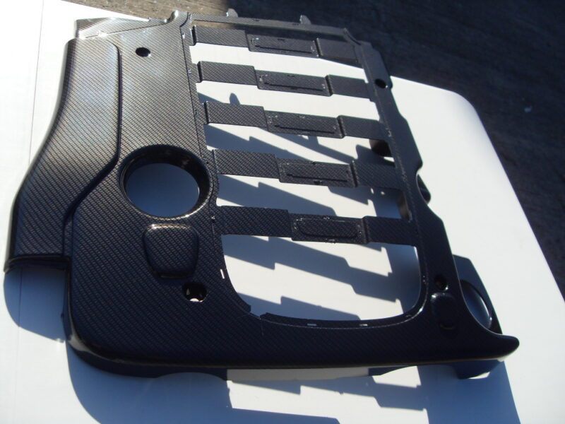 Car engine cover coated in carbon fibre hydrographic film painted black