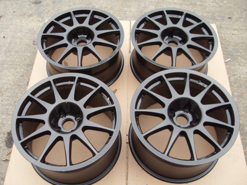 Car alloy wheels coated in carbon fibre painted black