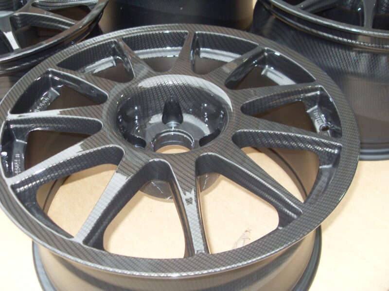 Car alloy wheels coated in carbon fibre painted black