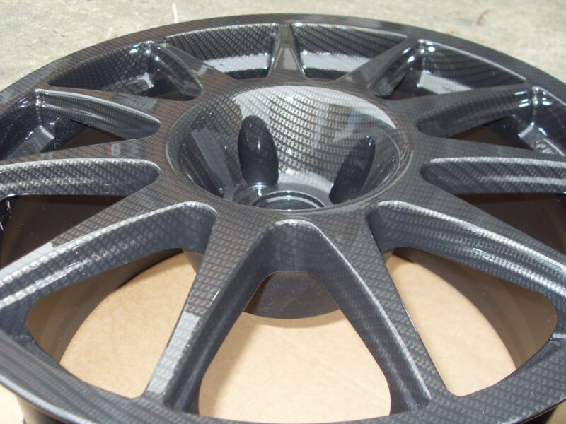 Car alloy wheels coated in carbon fibre painted black