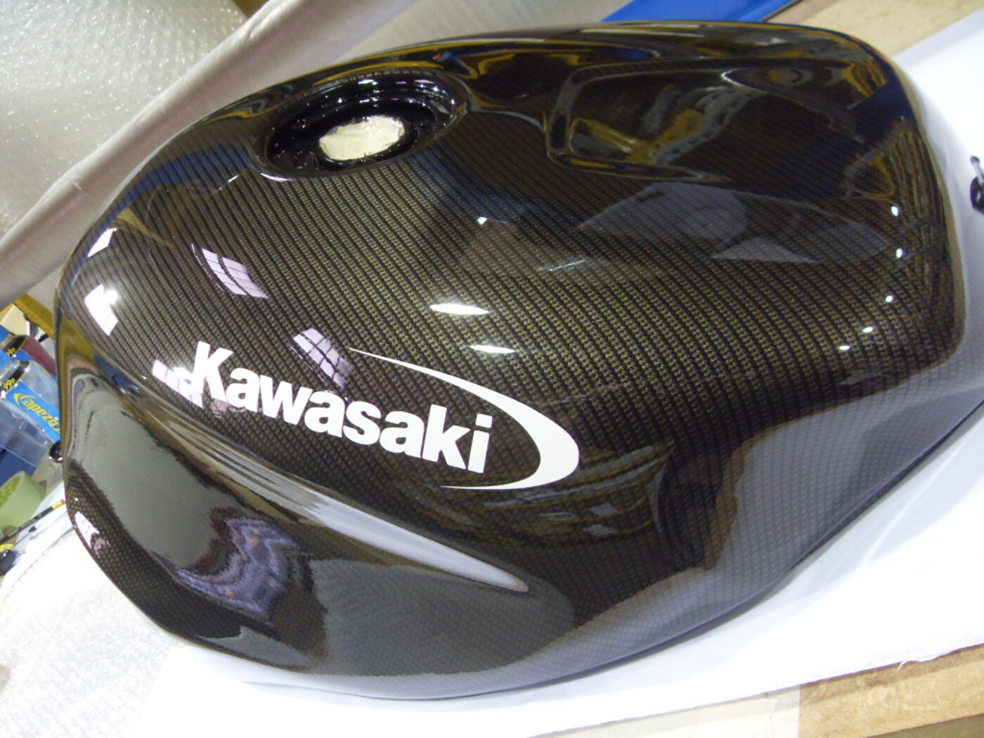 Motorbike tank coated in carbon fibre hydrographic film painted black