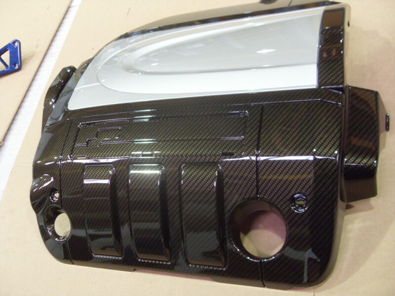 Engine cover coated in carbon fibre hydrographic film painted black