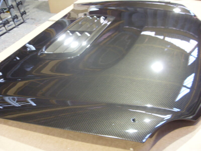 Car hood coated in carbon fibre hydrographic film painted grey