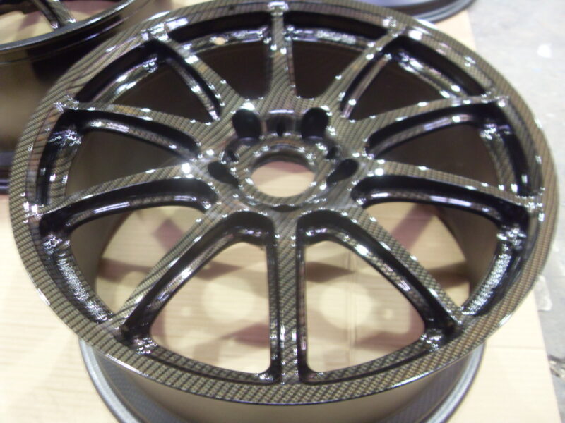 Car alloy wheels coated in carbon fibre painted black