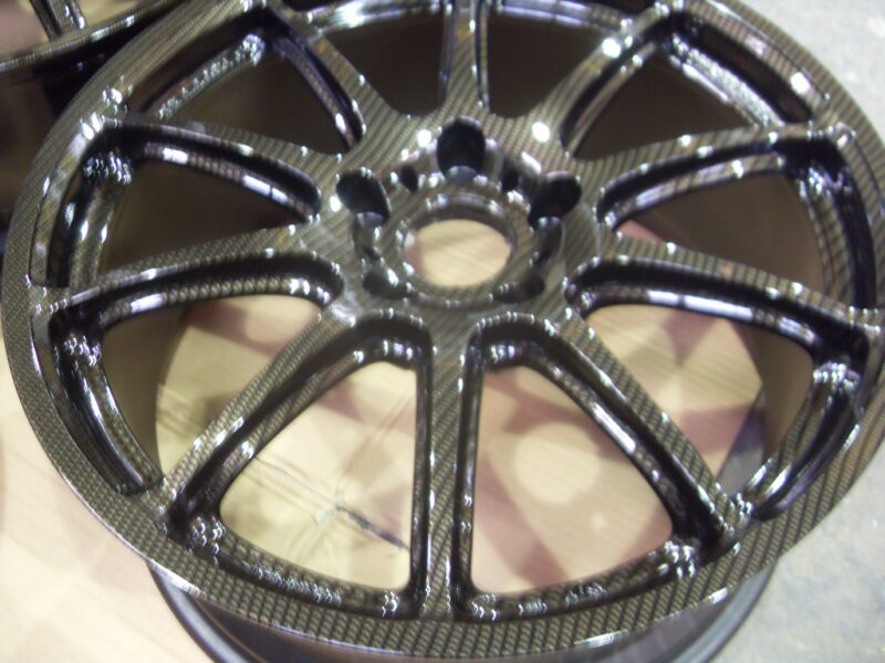 Car alloy wheels coated in carbon fibre painted black
