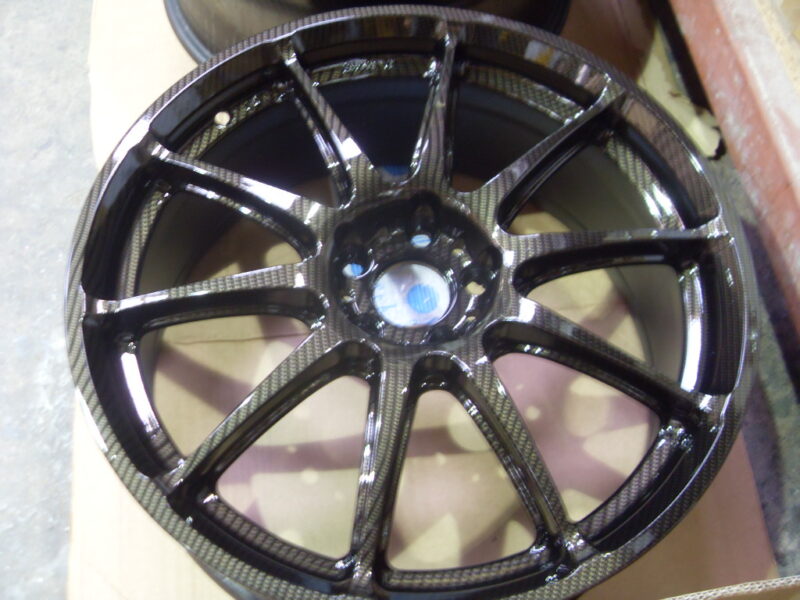 Car alloy wheels coated in carbon fibre painted black