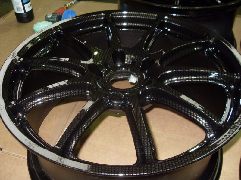 Car alloy wheels coated in carbon fibre painted black