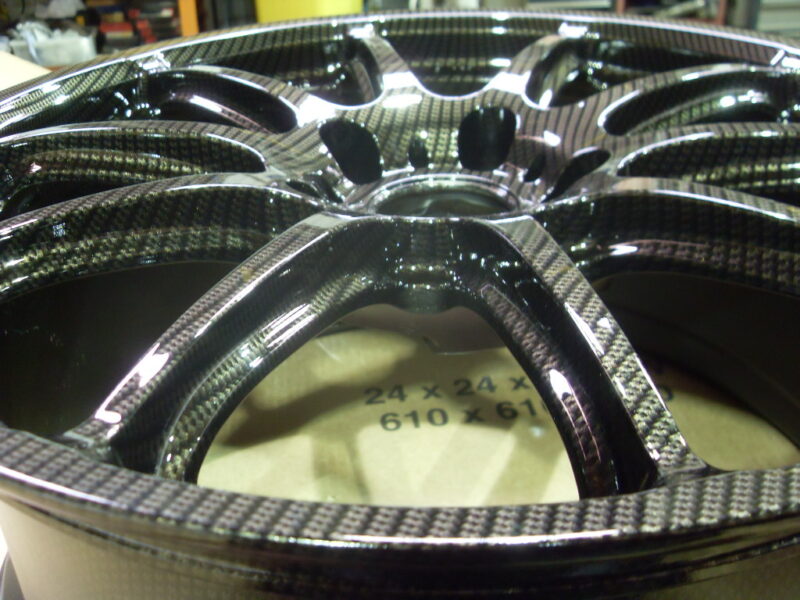 Car alloy wheels coated in carbon fibre painted black