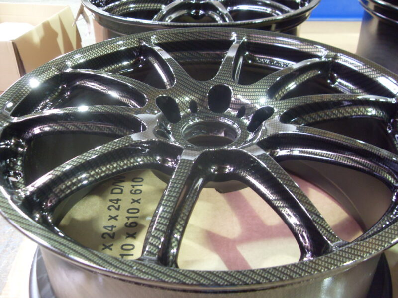 Car alloy wheels coated in carbon fibre painted black