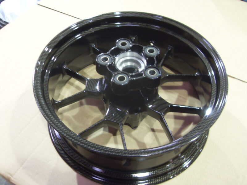 Motorbike alloy wheels coated in carbon fibre painted black