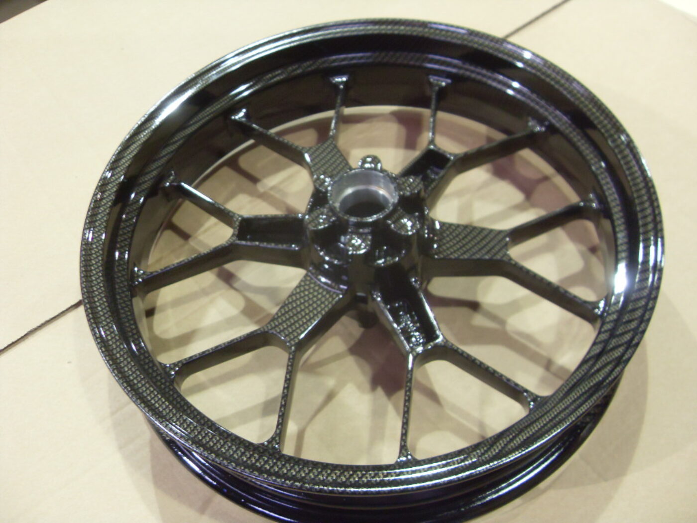 Motorbike alloy wheels coated in carbon fibre painted black