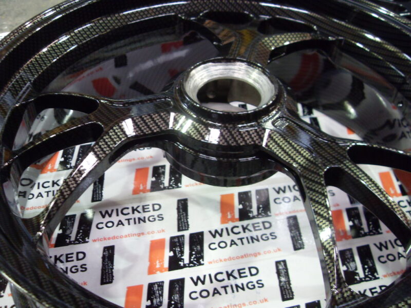 Motorbike alloy wheels coated in carbon fibre painted black