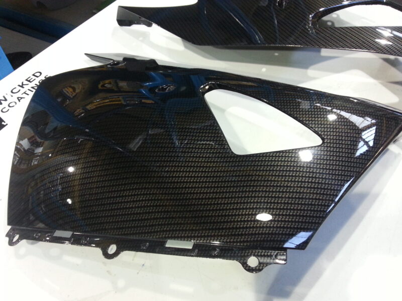 Motorbike parts coated in carbon fibre hydrographic film painted black