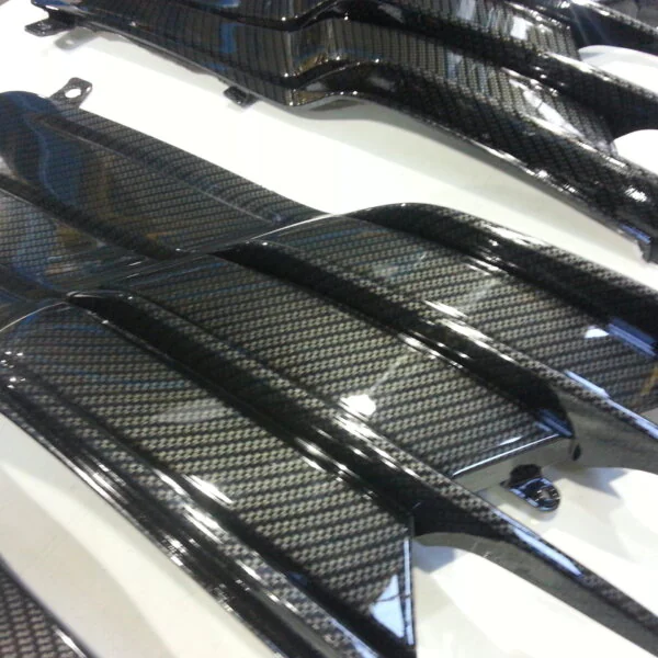 Motorbike parts coated in carbon fibre hydrographic film painted black