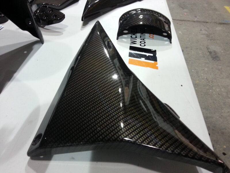 Motorbike parts coated in carbon fibre hydrographic film painted black