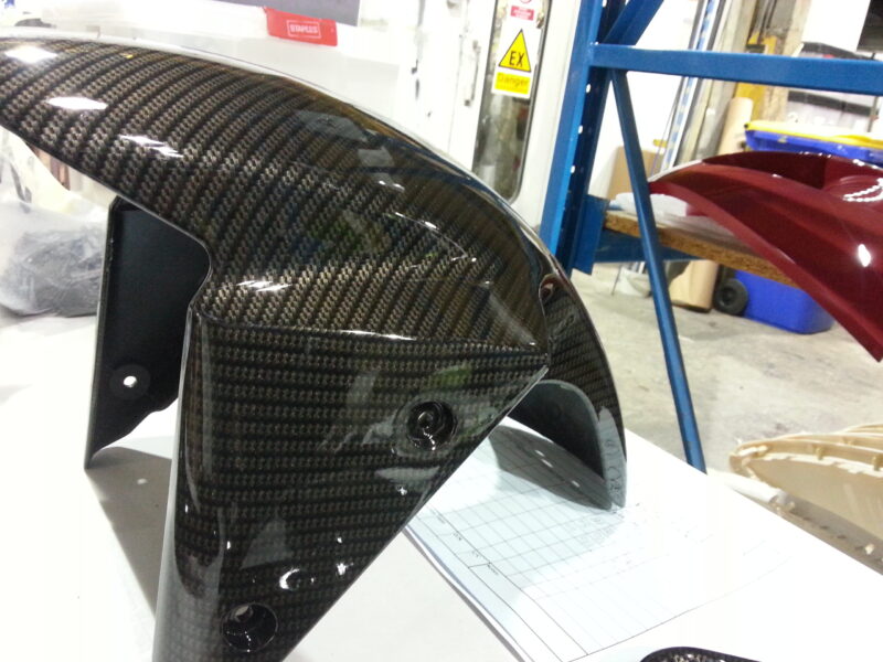 Motorbike parts coated in carbon fibre hydrographic film painted black