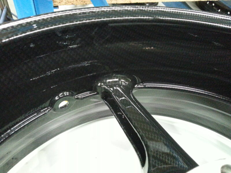 Motorbike alloy wheels coated in carbon fibre hydrographic film painted black
