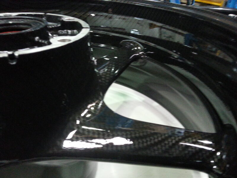 Motorbike alloy wheels coated in carbon fibre hydrographic film painted black