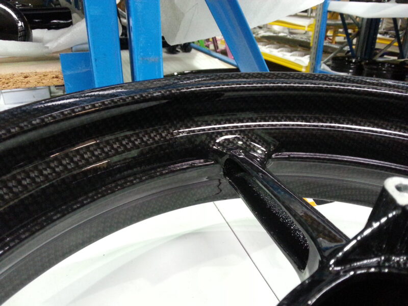 Motorbike alloy wheels coated in carbon fibre hydrographic film painted black