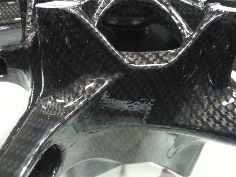 Motorbike alloy wheels coated in carbon fibre hydrographic film painted black
