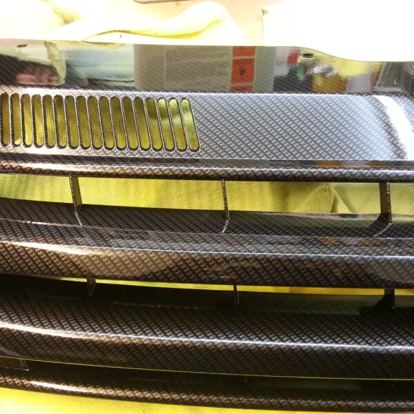 VW radiator grill coated in carbon fibre hydrographic film painted black