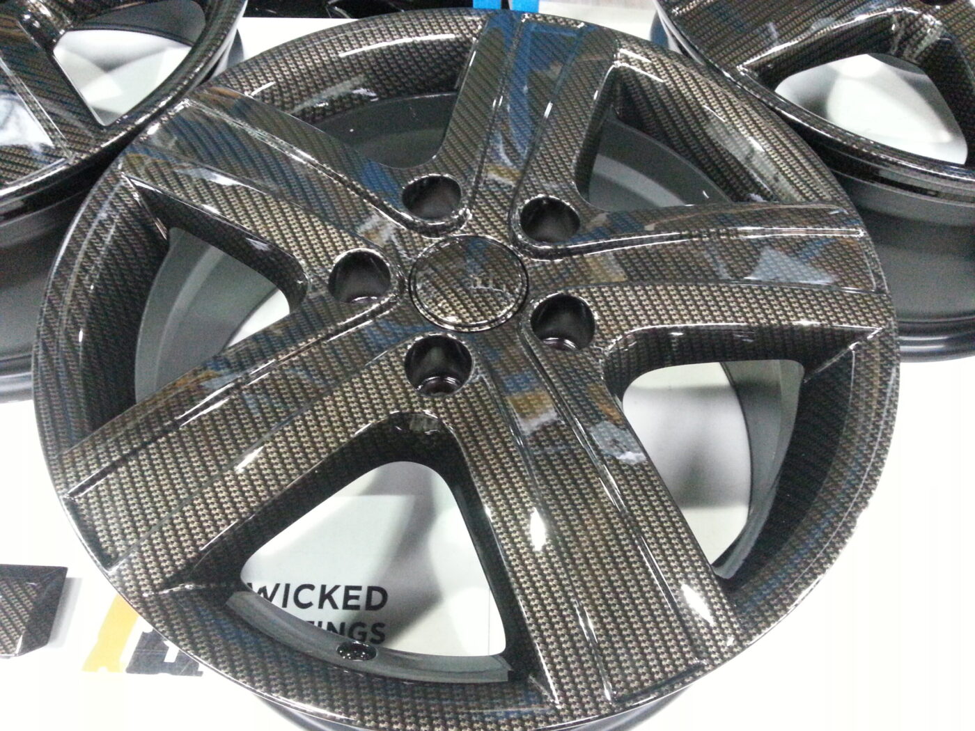 Car alloy wheels coated in carbon fibre hydrographic film painted black