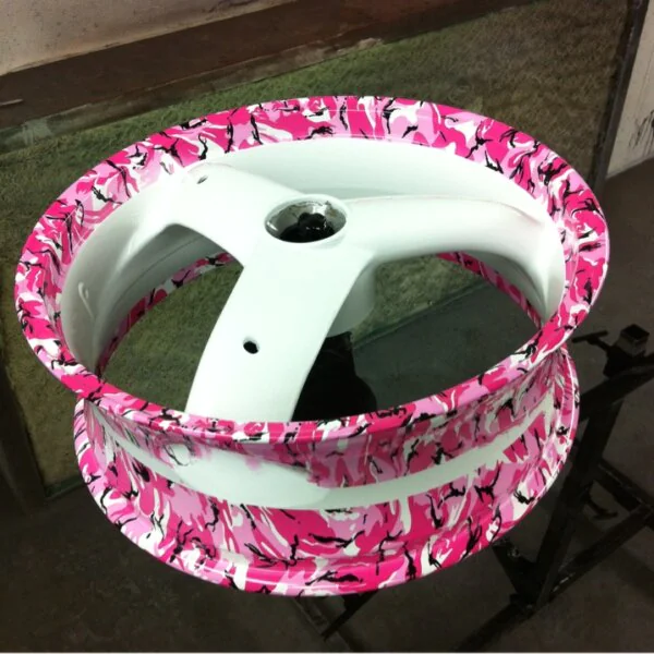 Pink abstract hydrographic film over white painted motorbike alloy wheels