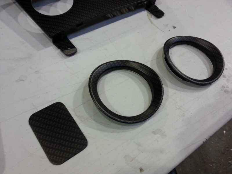 Car dashboard elements coat in carbon fibre hydrographic film painted black