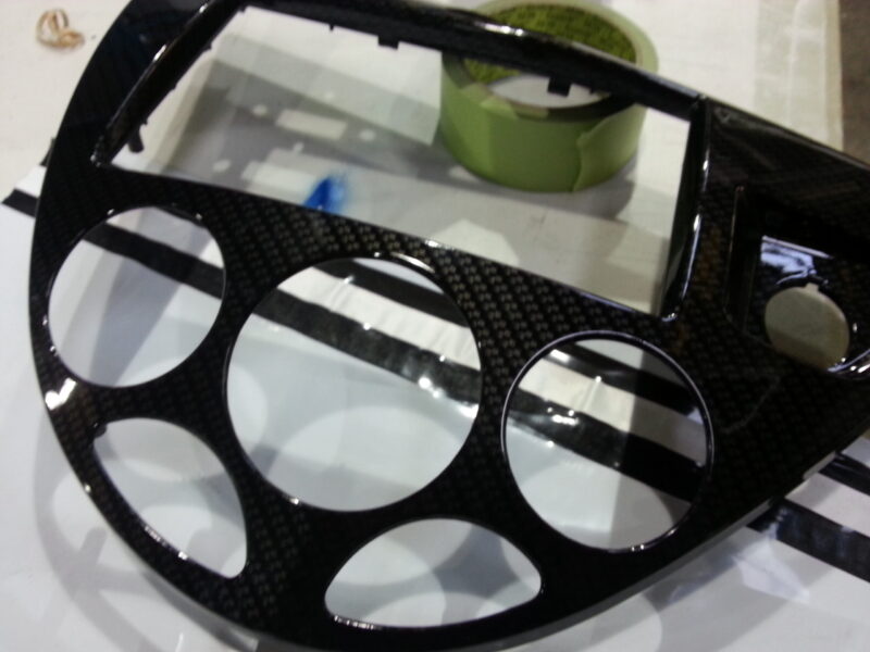 Car interior part coated in carbon fibre hydrographic film painted black