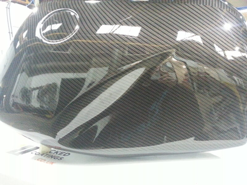 Motorbike tank coated in carbon fibre painted black